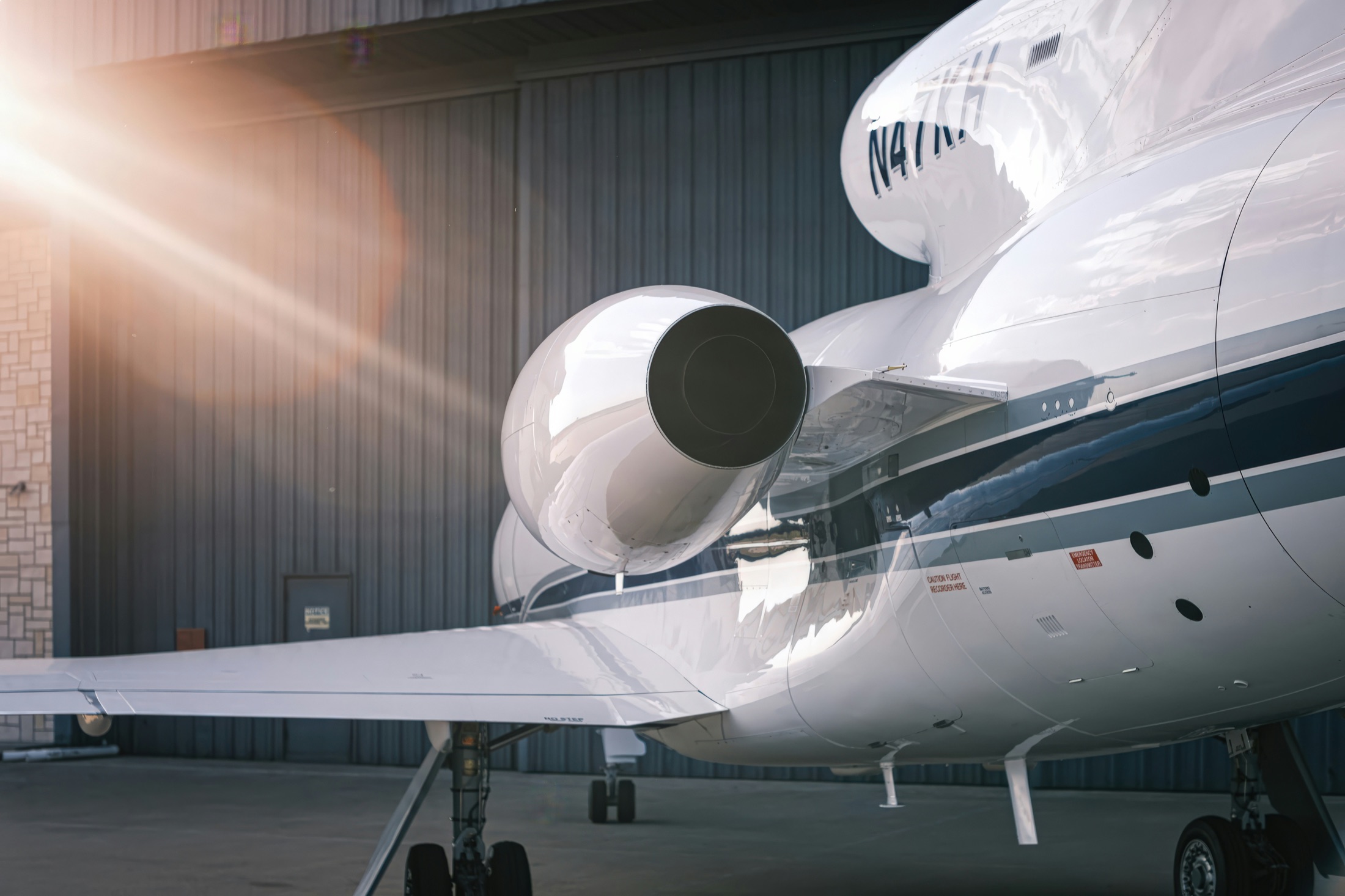 Private jet parked in a sunlit hangar