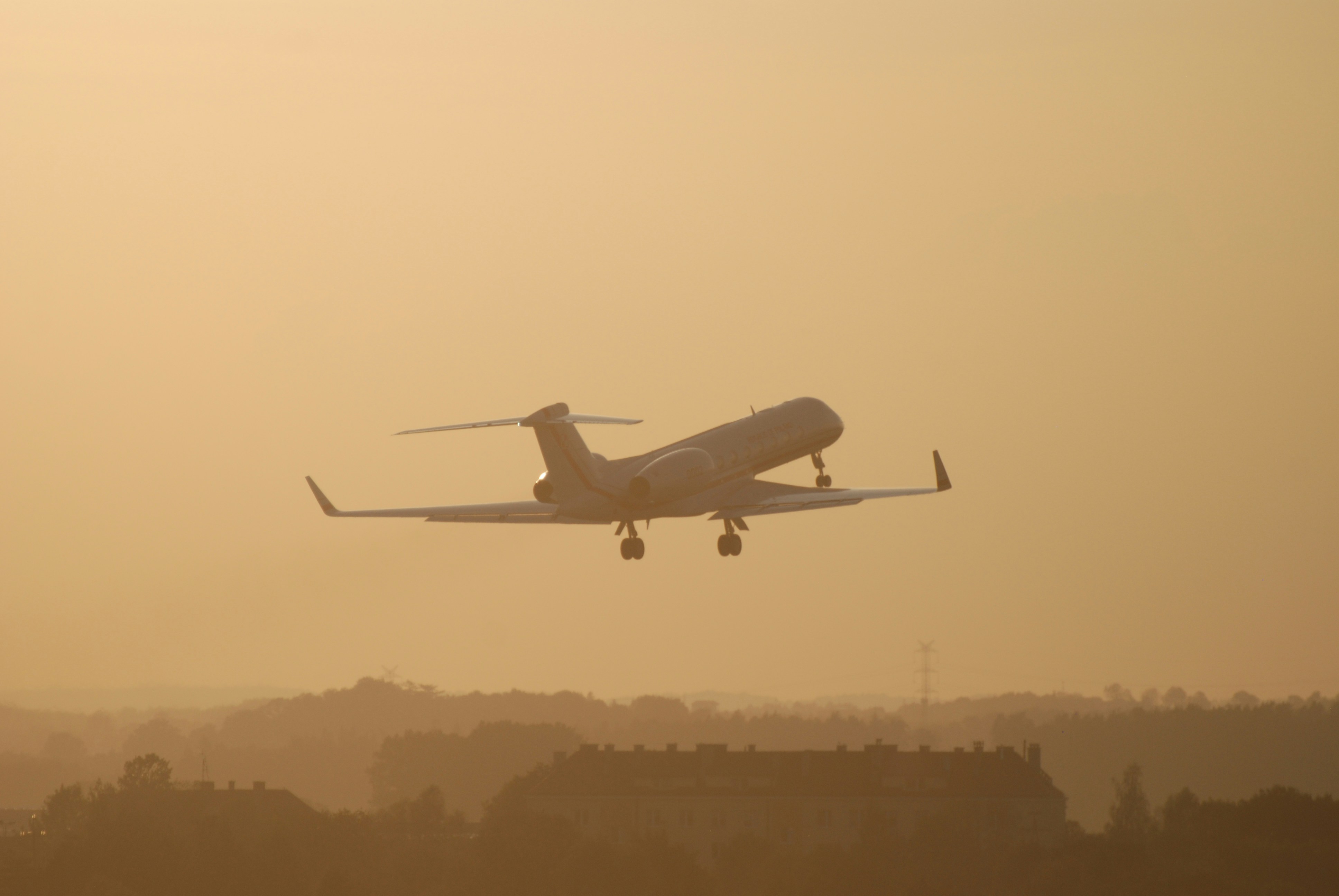 Private jet taking off through warm sunset light